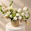 White floral arrangement in a gold textured vase with gold leaf accents