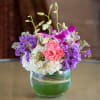 Pink roses and purple orchids in a glass vase