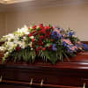 Freedom's Tribute Casket Spray is a classic red, white and blue arrangement