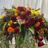 Large mixed bouquet of red roses, yellow blooms, and orange flowers