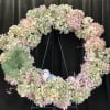 Pastel hydrangea wreath with a green bow and small bird ornament