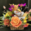 Basket arrangement with orange roses, lilies, and mixed fall flowers