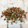 Large arrangement of red roses with yellow filler flowers on a white stand