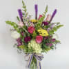 Mixed bouquet in a glass vase with pink, white, yellow, and purple flowers