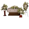 White funeral casket with floral sprays and standing arrangements