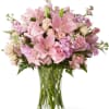 Pink roses and lilies arranged in a clear glass vase