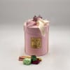 Pink gift box with ribbon and assorted chocolates in front