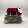 Red roses in a clear square box with a white orchid accent