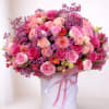 Large pink and purple rose bouquet in a white hat box with ribbon