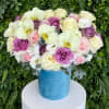 Mixed bouquet of roses and white orchids in a blue hatbox