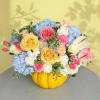 Colorful flower arrangement in a yellow pumpkin container