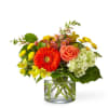 Mixed bouquet in a clear glass vase with orange and yellow flowers