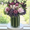 Bouquet of pink, purple, and white flowers in a tall glass vase