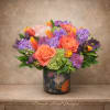 A radiant, garden-inspired floral arrangement featuring coral Free Spirit roses, vibrant fringed