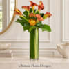Orange calla lilies and pincushion blooms in a tall green vase