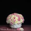 Round bouquet of pink and white roses in a white vase