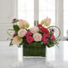 Pink roses and anthuriums in a square glass vase