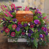 Colorful floral arrangement surrounding a wooden urn box