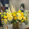 Yellow and white floral arrangement in a gold vase
