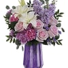 Bouquet of white lilies, pink roses, and purple flowers in a purple vase