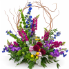 Tall mixed bouquet with blue, purple, pink, and yellow flowers in a low base