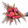 Handheld bouquet of pink dahlias and roses with dark foliage