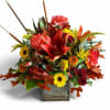 Autumn floral arrangement with red lilies and yellow sunflowers in a rustic wooden container