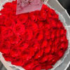Large bouquet of red roses wrapped in white paper