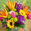 Bright mixed bouquet with orange lilies, pink roses, purple flowers, and sunflowers in a glass vase