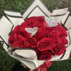 Bouquet of red roses wrapped in white paper with black trim