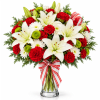 Red and white bouquet with lilies, carnations, and daisies in a glass vase