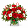Christmas bouquet of red roses, white daisies, and red carnations in a glass vase