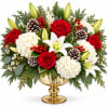 Red roses and white lilies in a gold vase with pinecones