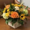 Orange roses and yellow flowers arranged in a wooden box