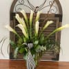 White calla lilies in a glass vase with a striped ribbon