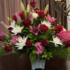 Bouquet of red roses, pink lilies, white daisies, and pink hydrangeas in a vase