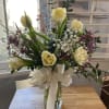 Bouquet of pale yellow tulips and small white flowers in a glass vase