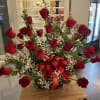 Basket arrangement of red roses with baby's breath and a red ribbon