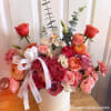 Pink and coral rose bouquet in a white hat box with a ribbon bow