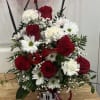 Red roses and white daisies arranged in a Mickey Mouse mug with a red balloon