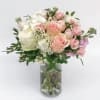 Pink and white rose bouquet in a clear glass vase