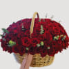 Basket filled with red roses and small eucalyptus sprigs