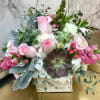 Pink roses and white blooms arranged with succulents in a wooden box
