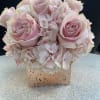 Pink roses and hydrangeas arranged in a square vase