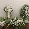 Four white floral funeral arrangements with lilies and roses