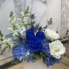 Blue and white floral arrangement in a white square vase
