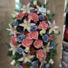 Large standing floral spray with pink lilies, roses, and blue roses