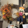 Fall wreath with sunflowers and a scarecrow decoration on a wall