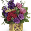 Mixed pink, purple, and red roses in a decorative yellow box with a "celebrate" sign