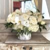 White roses and orchids arranged in a marble vase